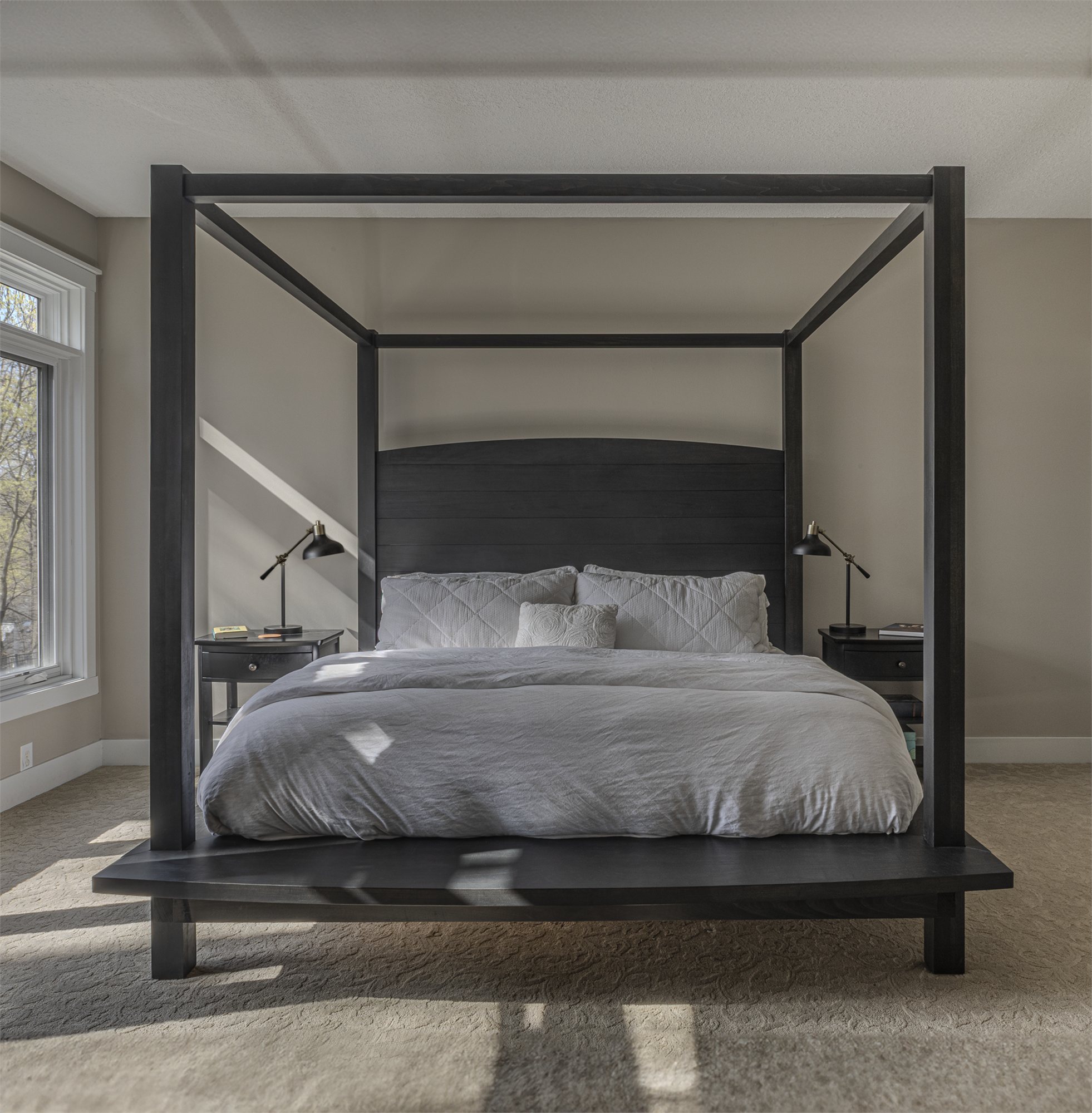 A four posted king bed in solid hardwood with a paneled headboard