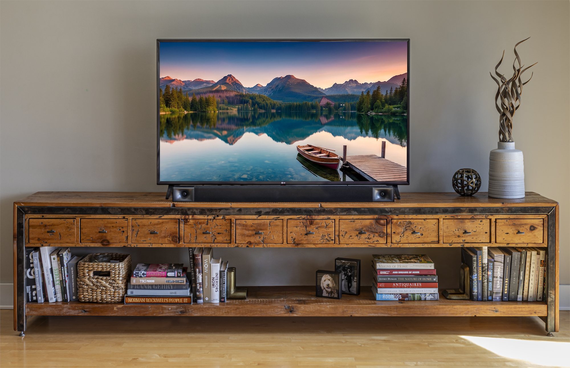 A one of one media console with fluted doors set beneath a wall-mounted screen