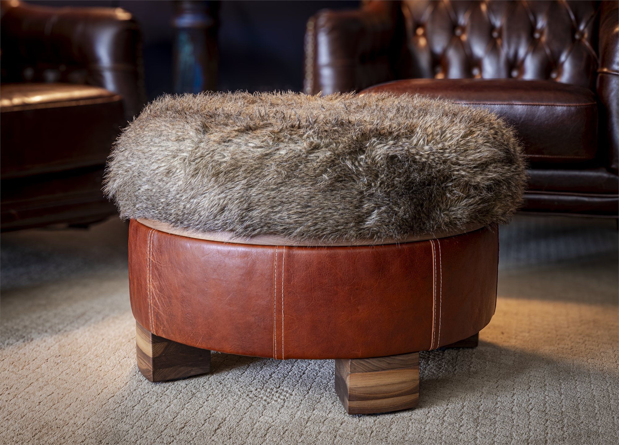 A walnut framed ottoman with a stitched leather top